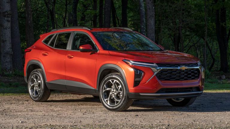 Chevrolet Trax LT in Cayenne Orange Metallic parked on a gravel road in front of trees.